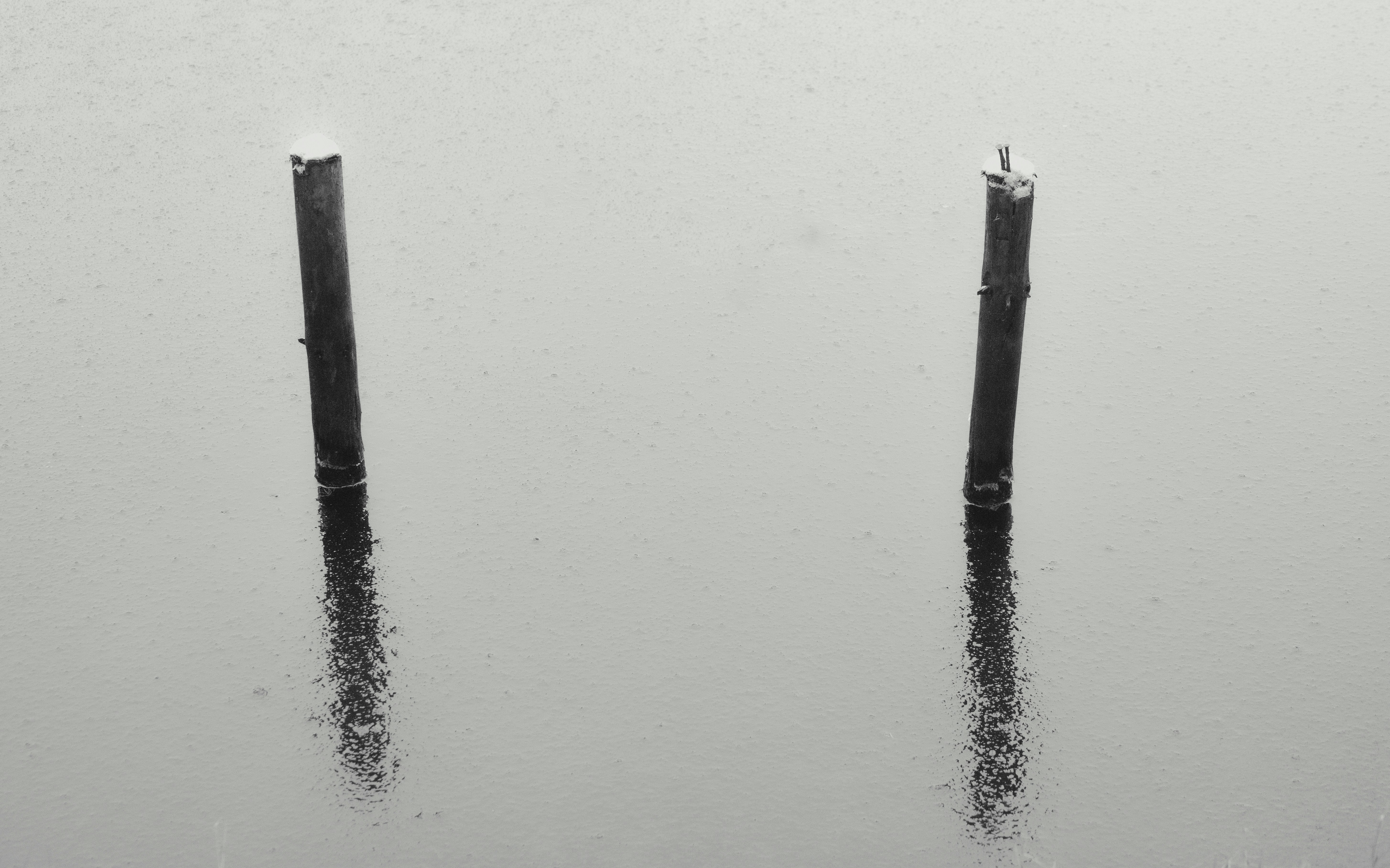 two poles sticking out of the water in the rain