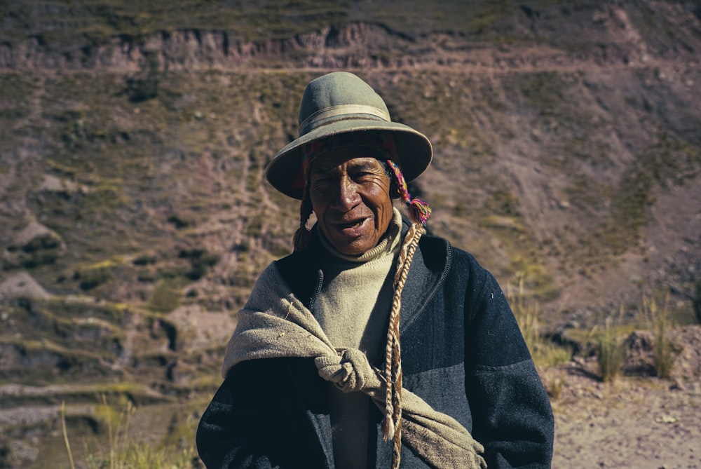 Hombre con chaqueta negra y sombrero marrón