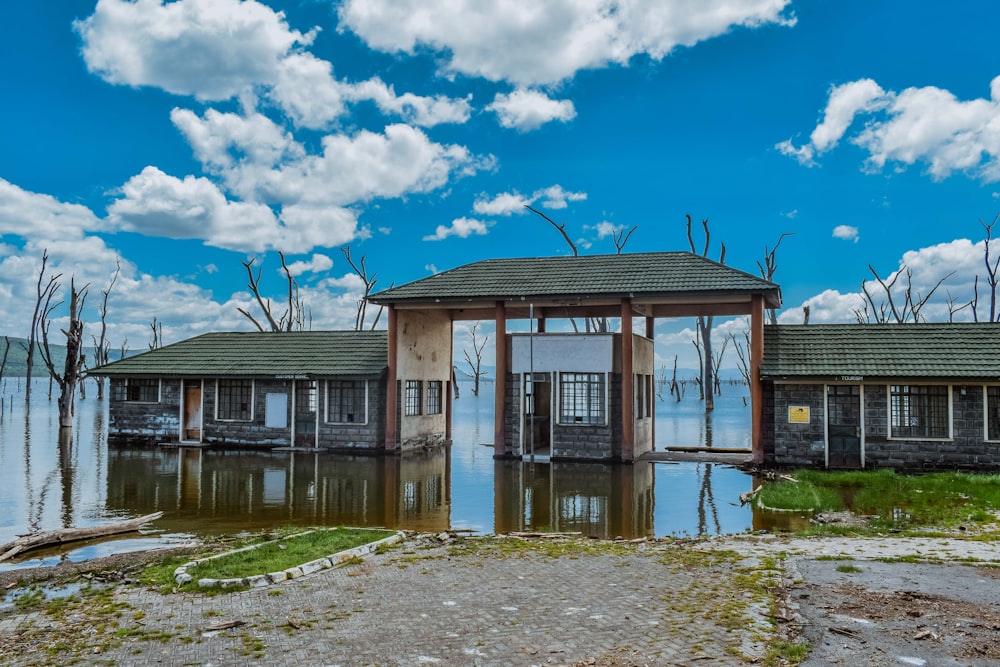 brown wooden house near body of water under blue sky during daytime