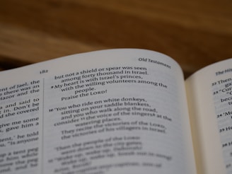 An open book displaying text from the Old Testament. The page number is 182, and the content is organized in a two-column format with headers and verses. The text includes references to Israel, praising the Lord, and mentions of riders on white donkeys.