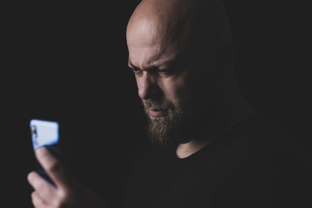 man in black crew neck shirt, a man taking a selfie with a cell phone