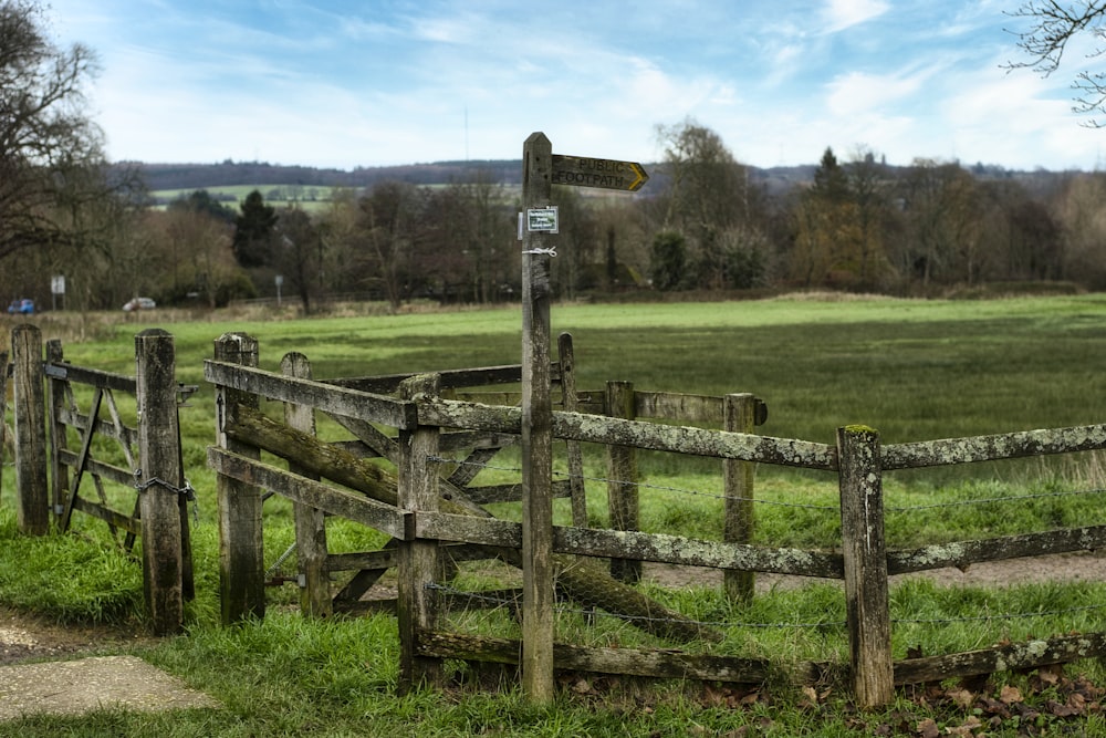 brown wooden fence on green grass field during daytime