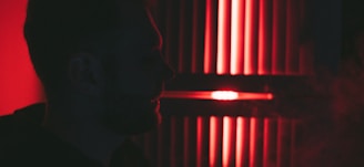 A moody, cinematic frame of a lone figure silhouetted against a vibrant red backdrop.