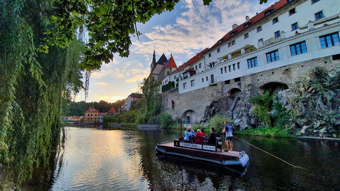 people riding on boat on river near concrete building during daytime