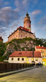 brown and white concrete building near green trees under blue sky during daytime