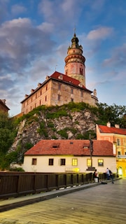 brown and white concrete building near green trees under blue sky during daytime