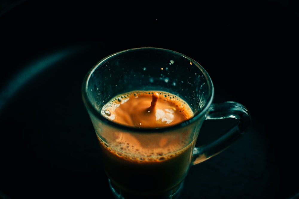 clear glass mug with brown liquid