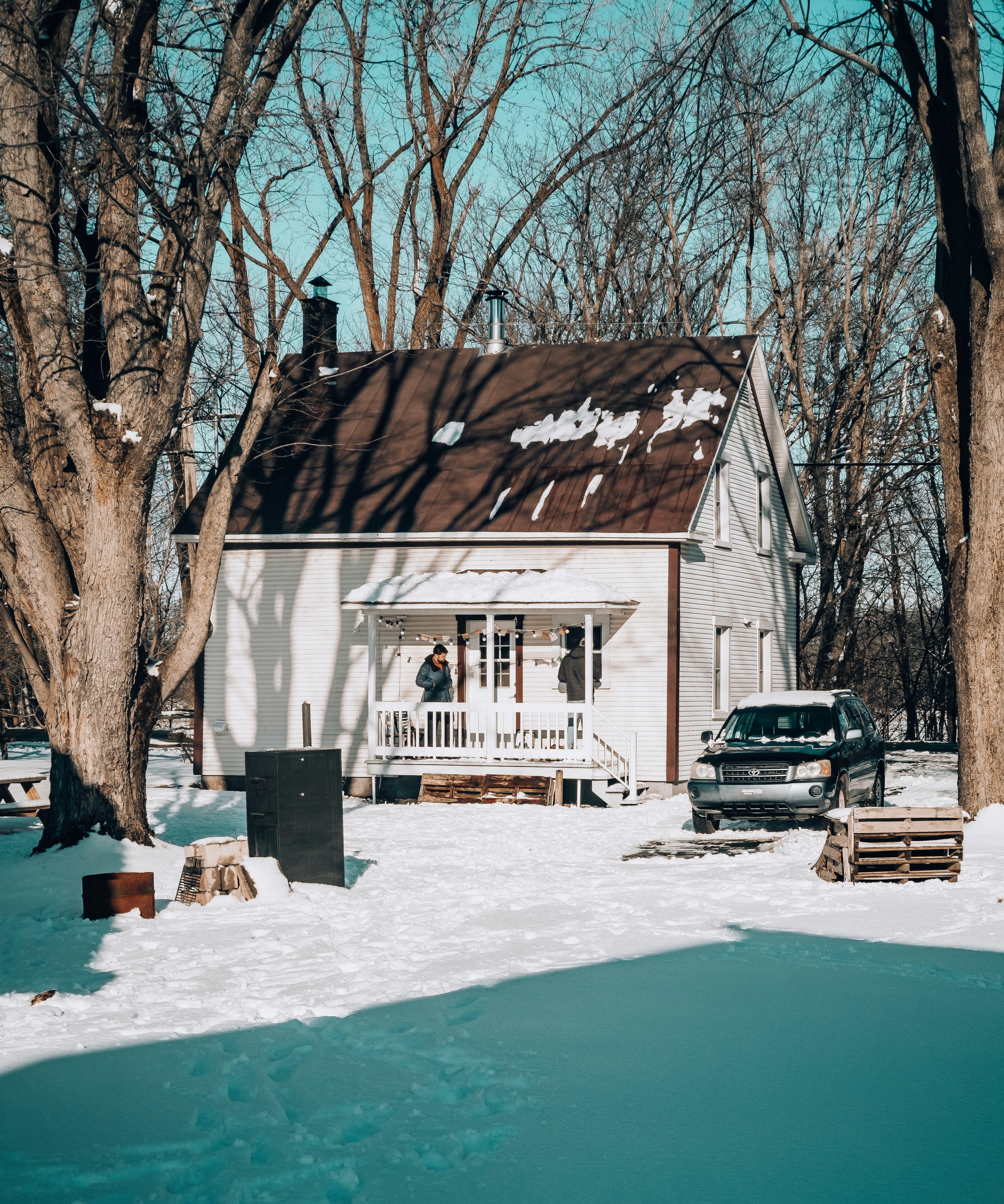 black car parked beside white and brown house during daytime