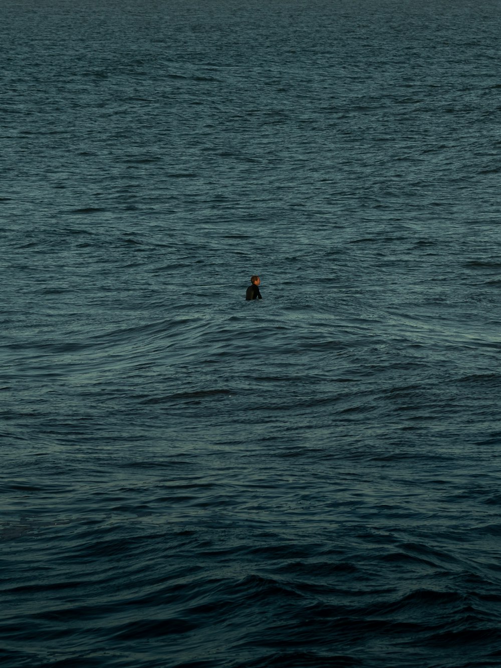 Person im roten Hemd schwimmt tagsüber auf See