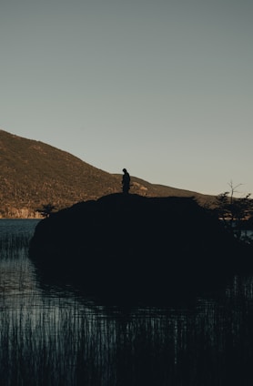 A serene figure standing atop rocky cliffs at sunrise, symbolizing personal liberation and clarity.