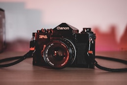 black nikon dslr camera on brown wooden table