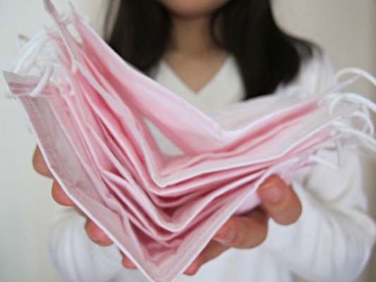 woman in white long sleeve shirt holding pink and white scarf
