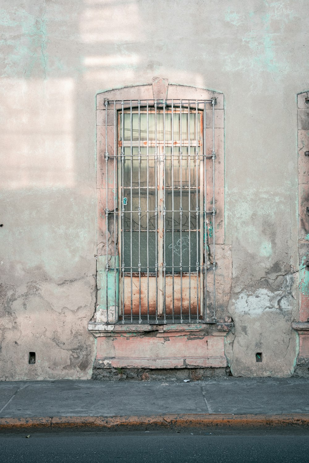 blue metal window grill on gray concrete wall