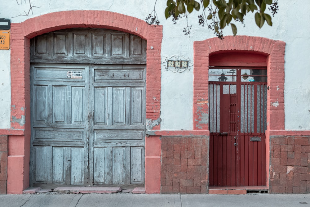 red wooden door beside green plant