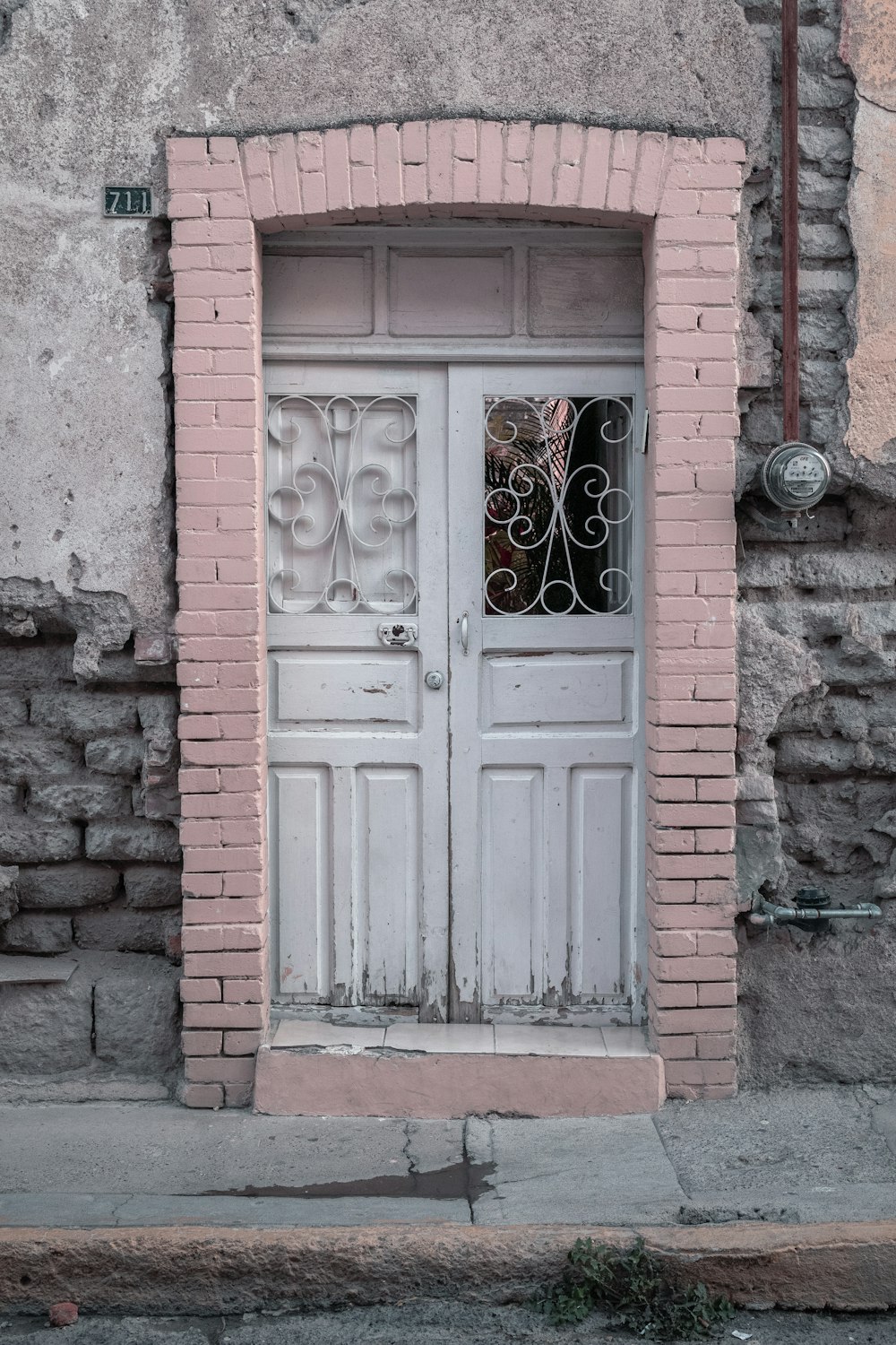 porta de madeira branca na parede marrom do tijolo