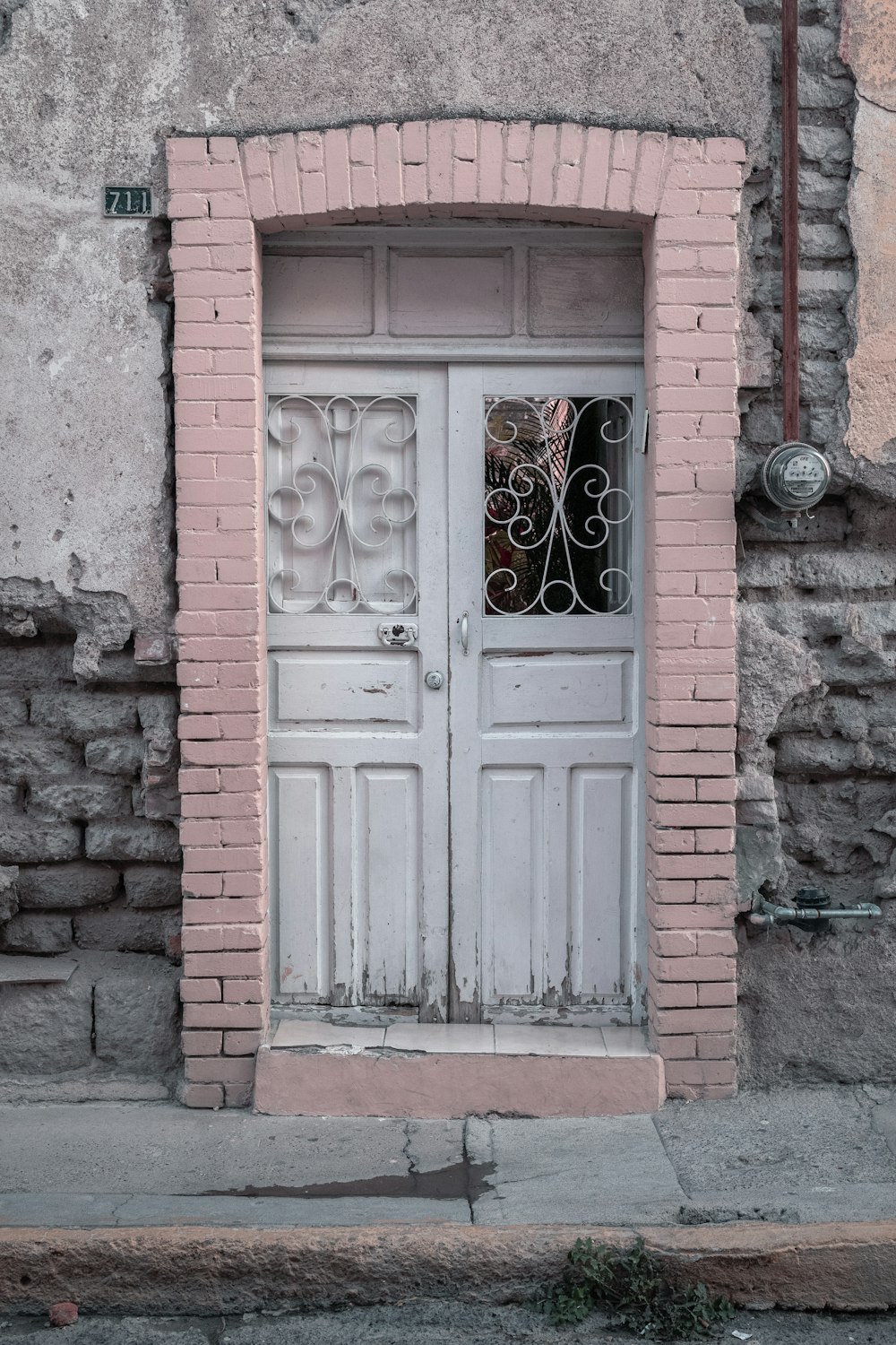 white wooden door on brown brick wall