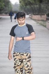 An outdoor scene with a person wearing a military watch.