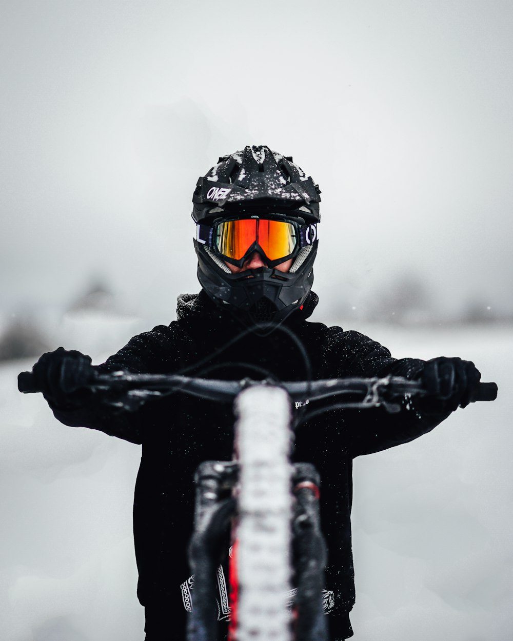 person in black jacket and black helmet riding black snowboard