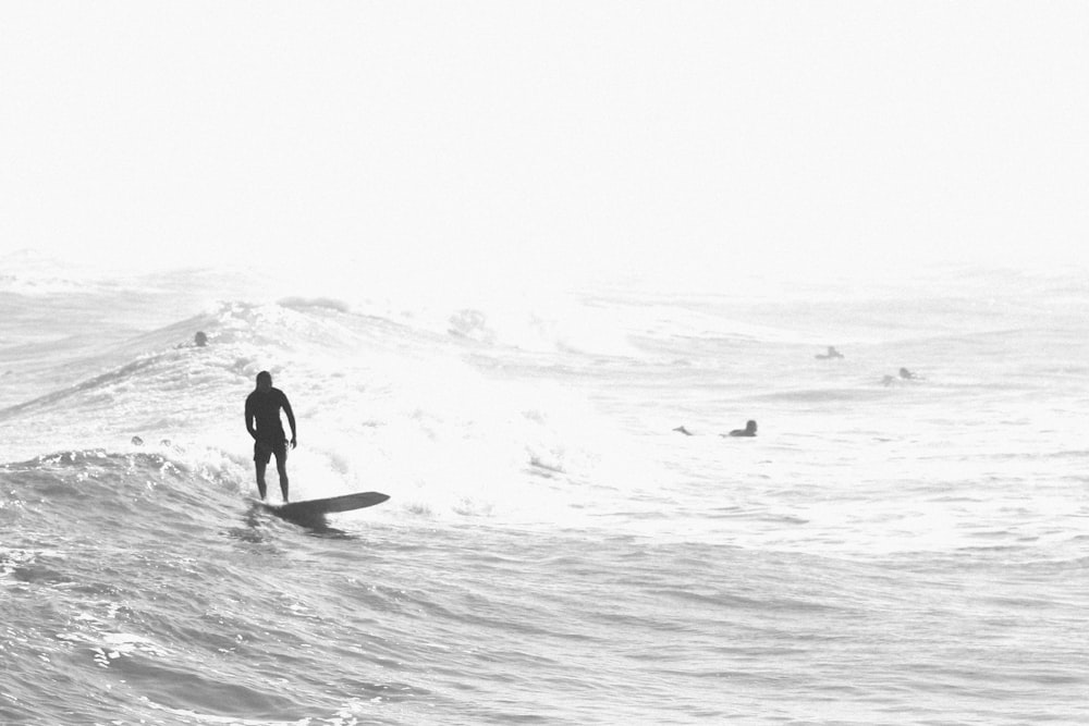 man in black wet suit walking on beach shore during daytime