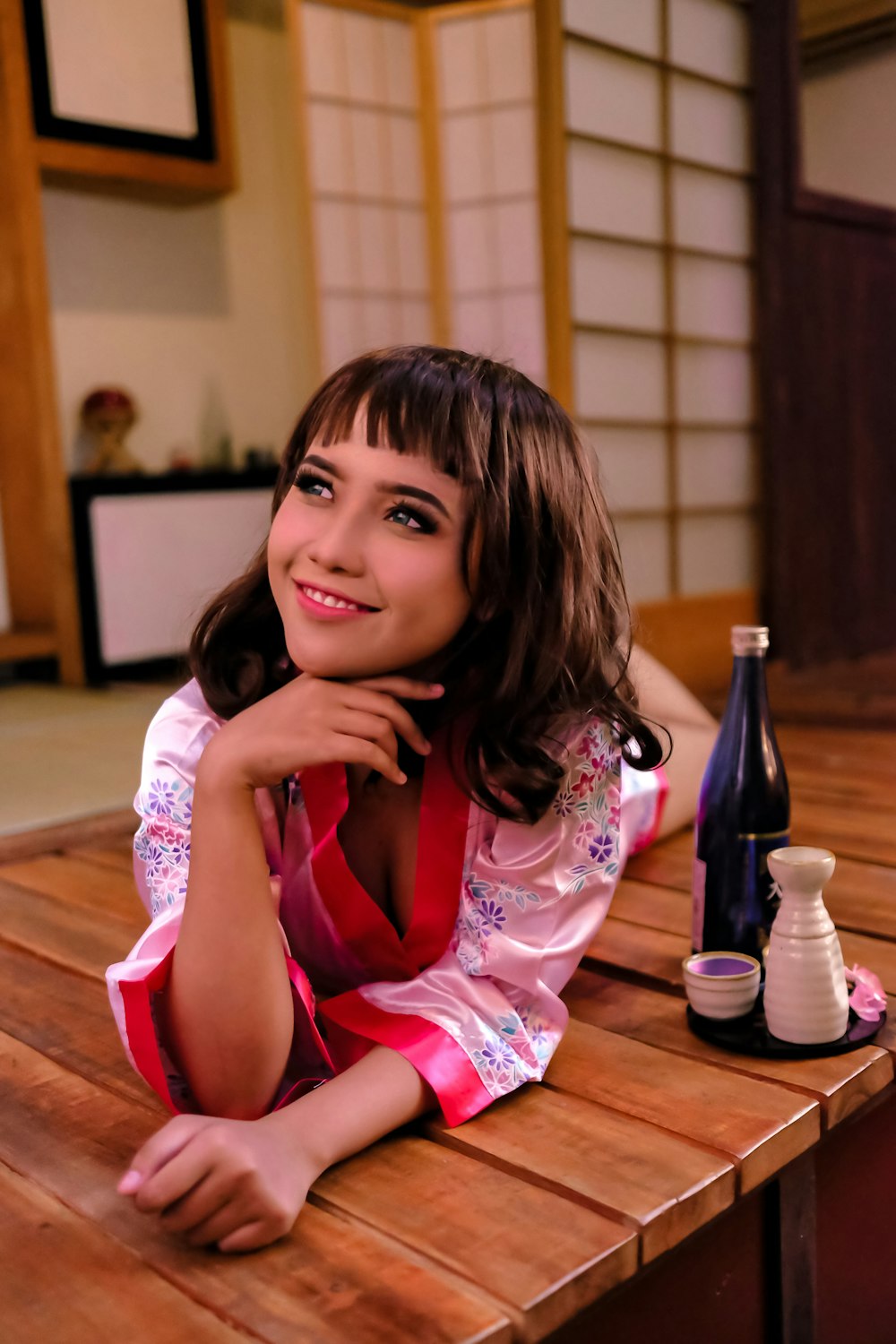 girl in pink and white floral dress sitting on brown wooden chair