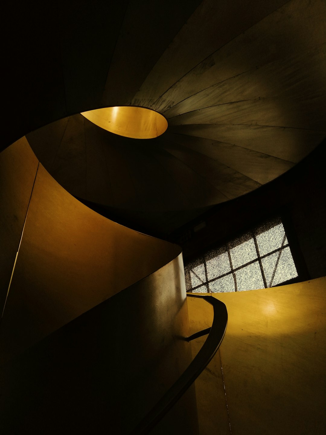 brown spiral staircase with black metal railings