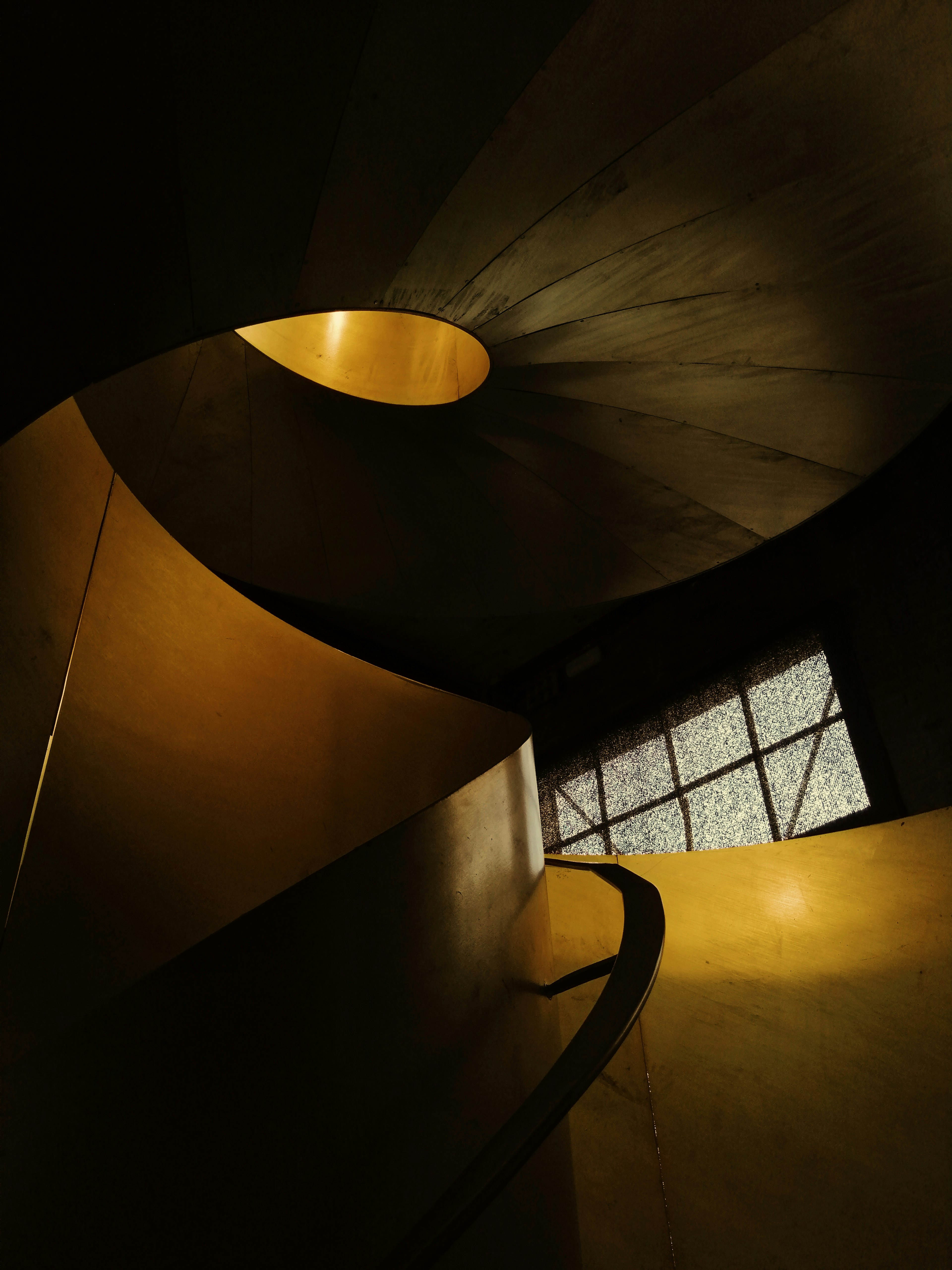 brown spiral staircase with black metal railings