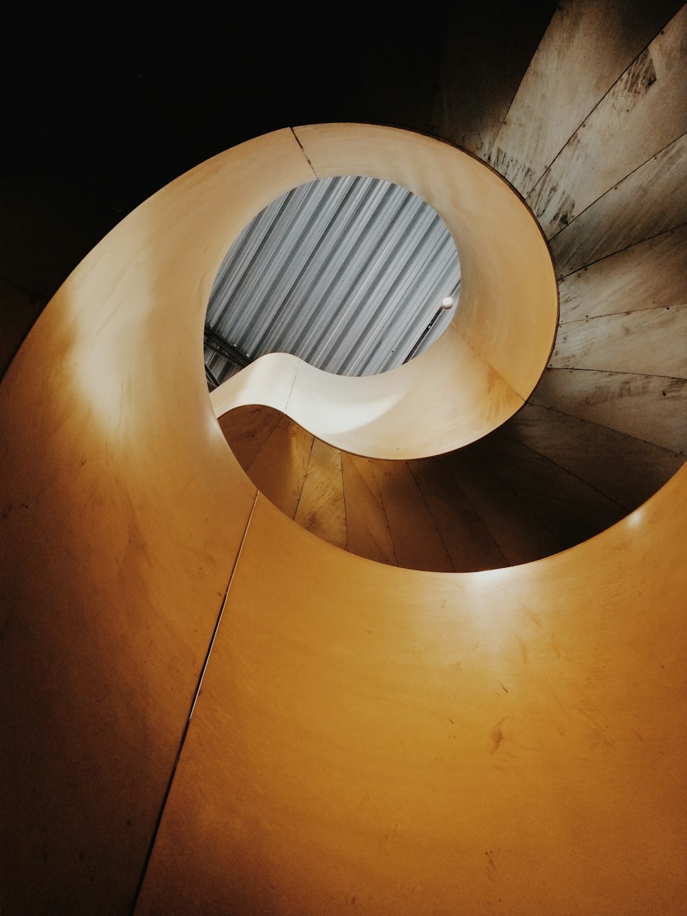 brown spiral staircase with white metal railings