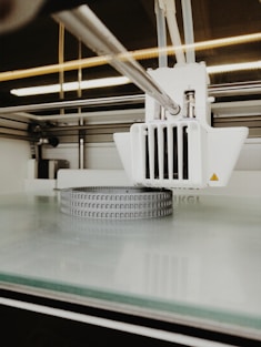 A close-up of a 3D printer in action, carefully layering plastic to create a custom-designed household organizer.