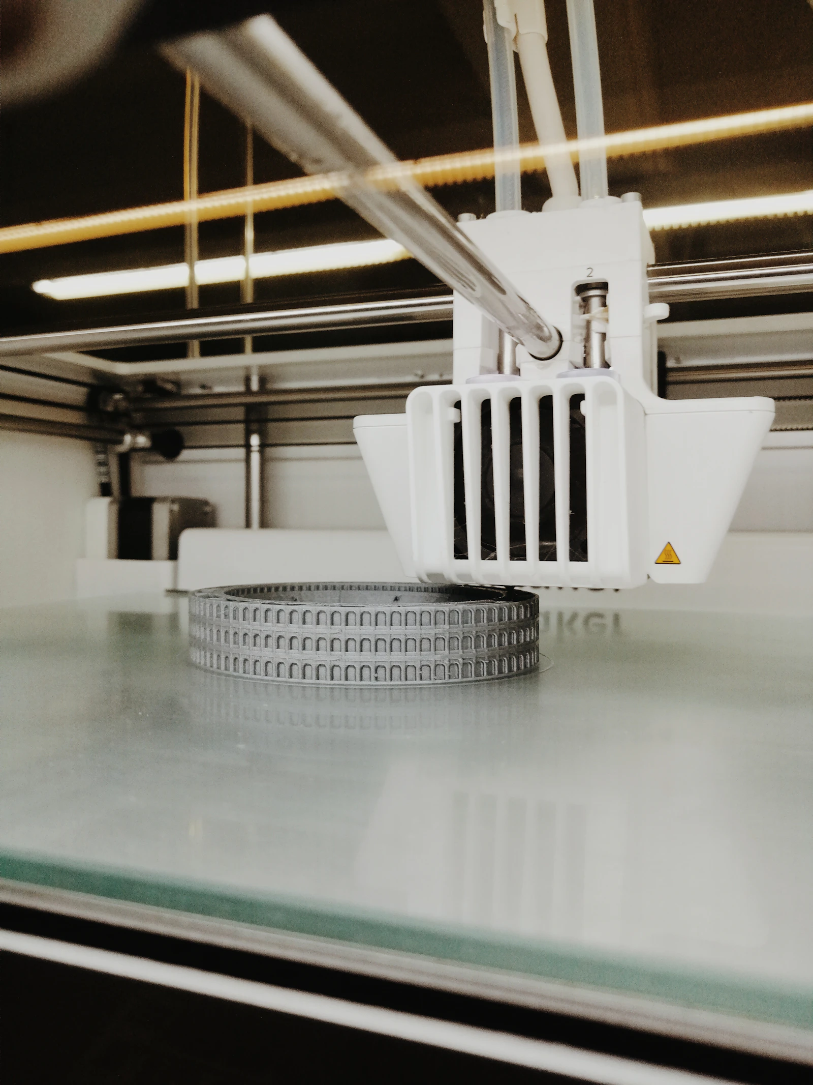 A 3D printer producing a round, toothed mechanical change part