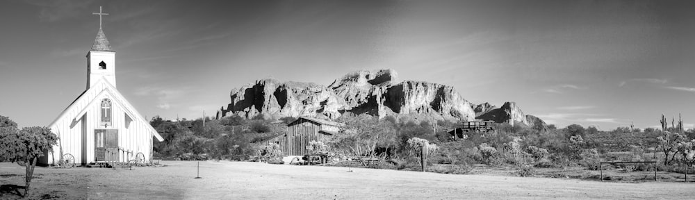 grayscale photo of house near mountain