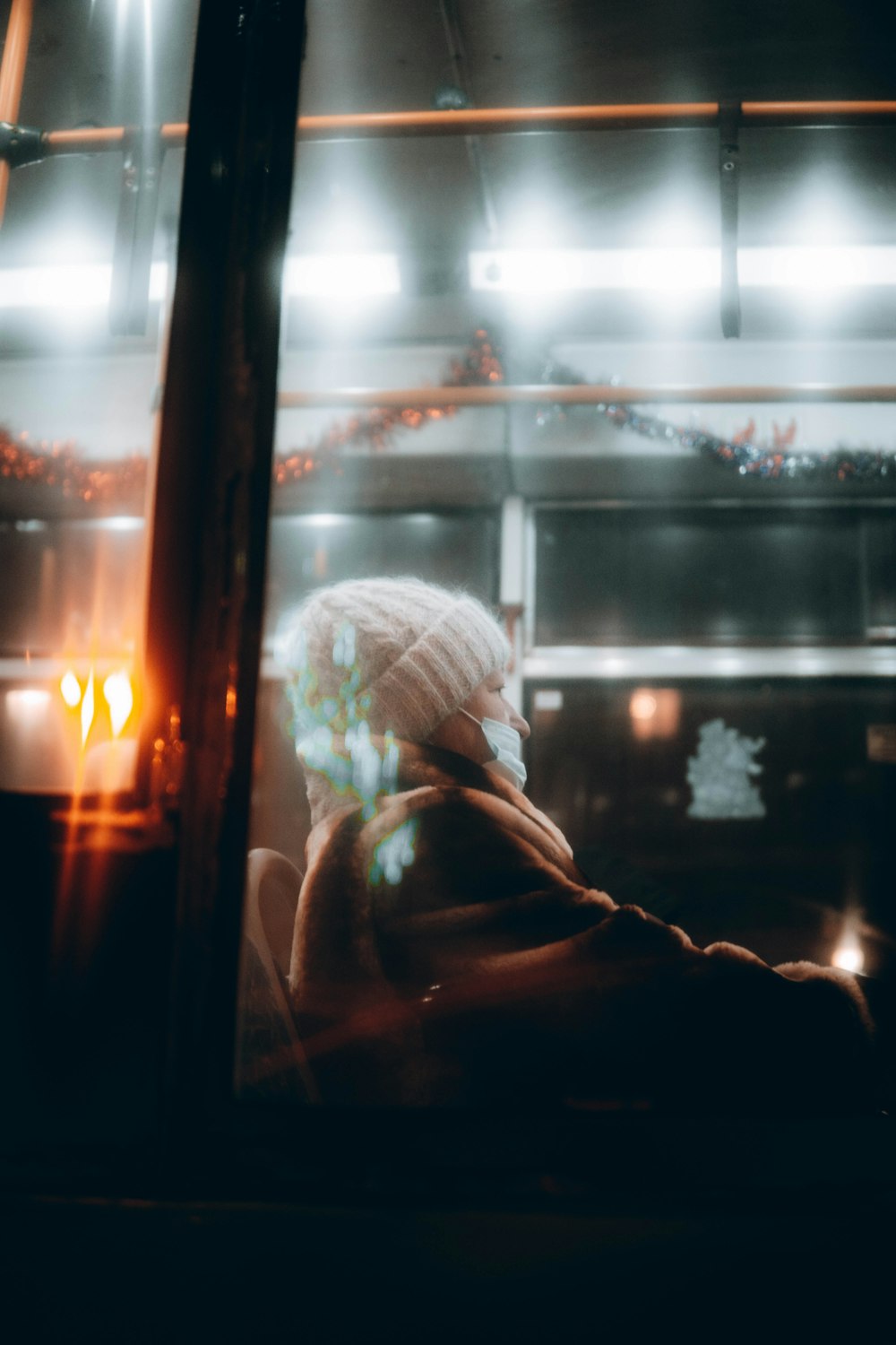 woman in white knit cap standing near window