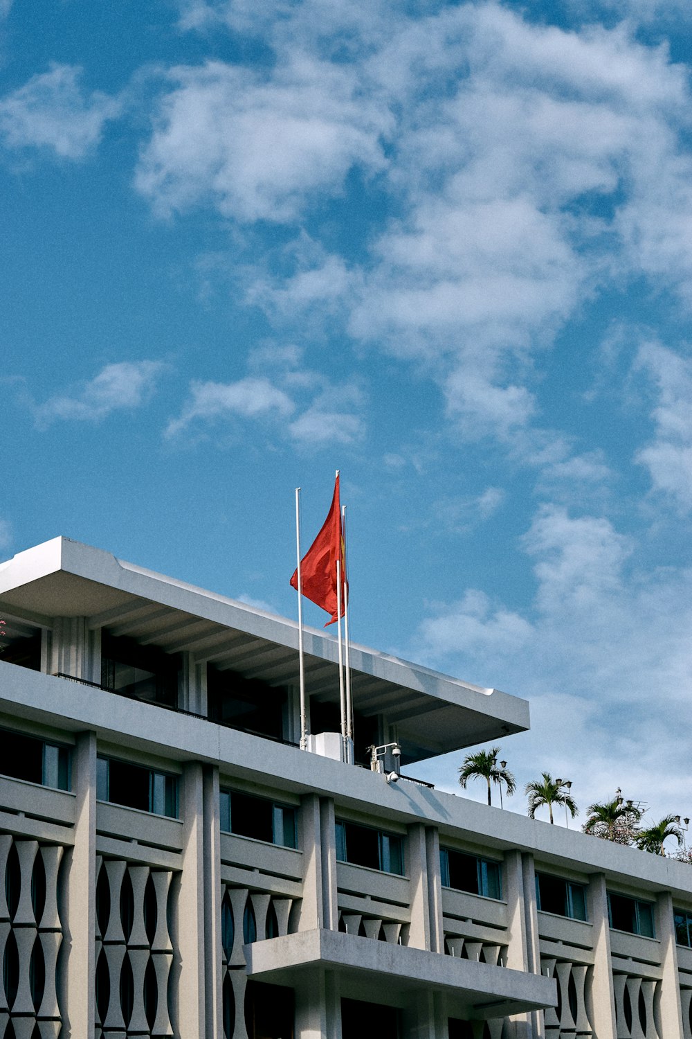 white and red flag on white pole under blue sky during daytime