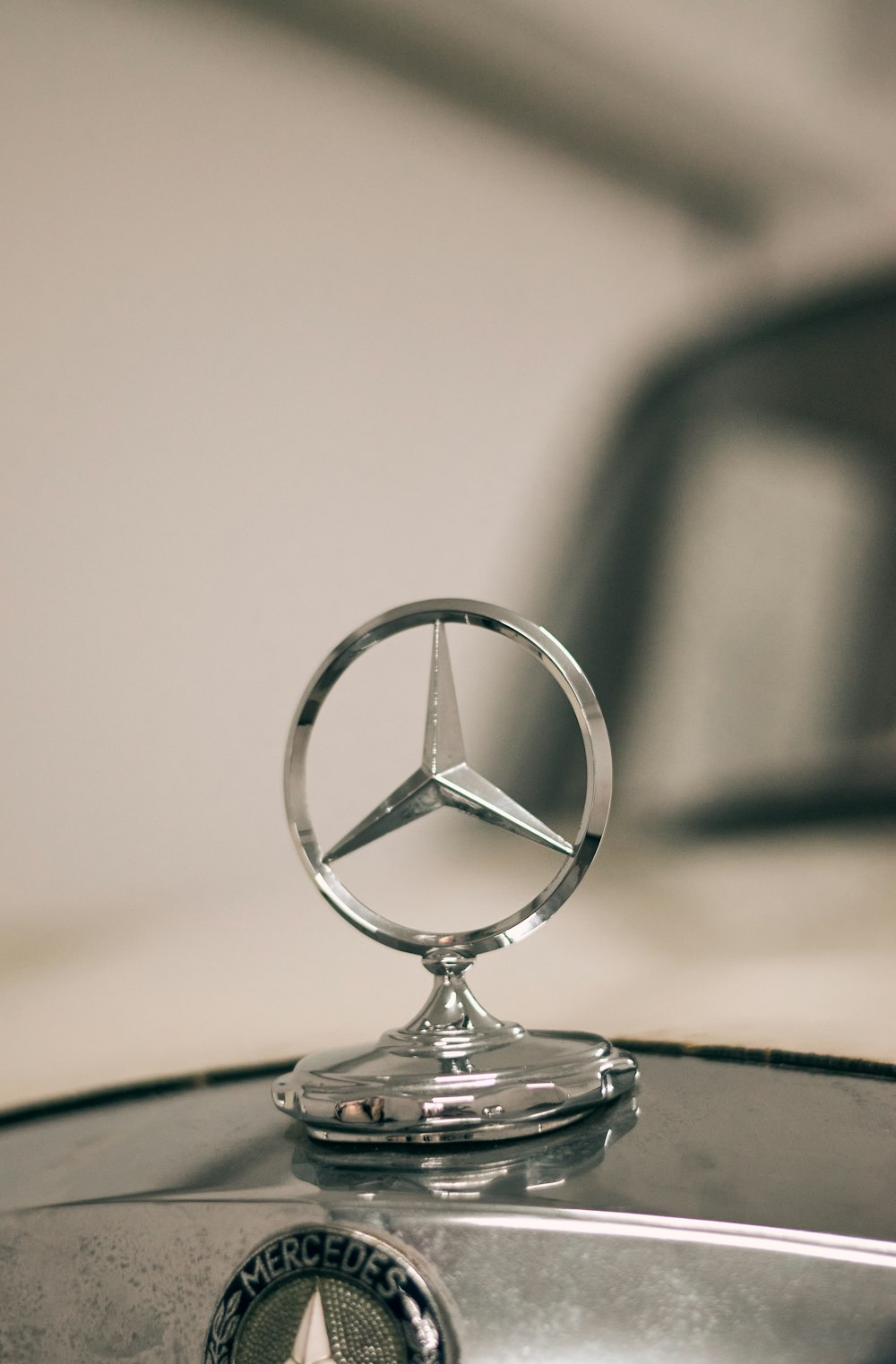 silver mercedes benz emblem on black surface