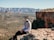 man in white dress shirt and black pants sitting on brown rock during daytime