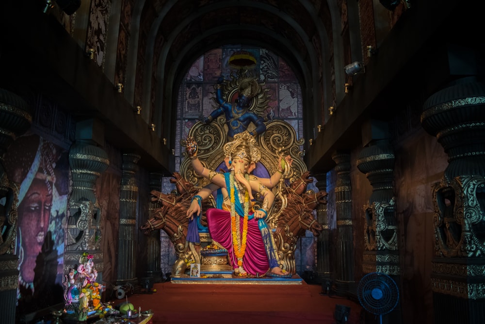 gold hindu deity statue on brown wooden table