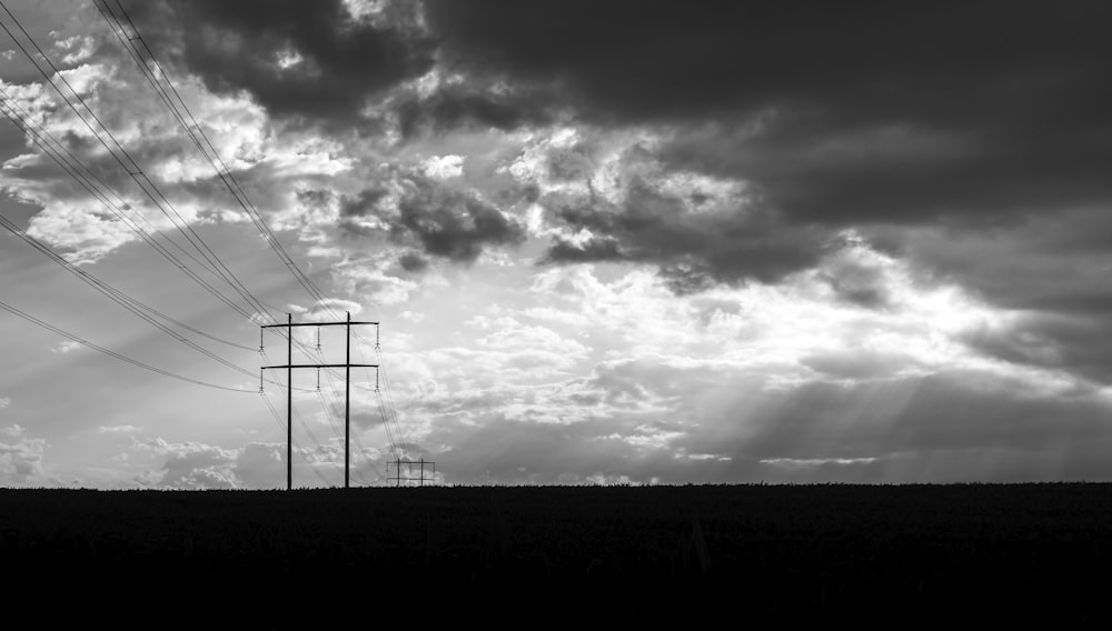 Una foto en blanco y negro de líneas eléctricas y nubes