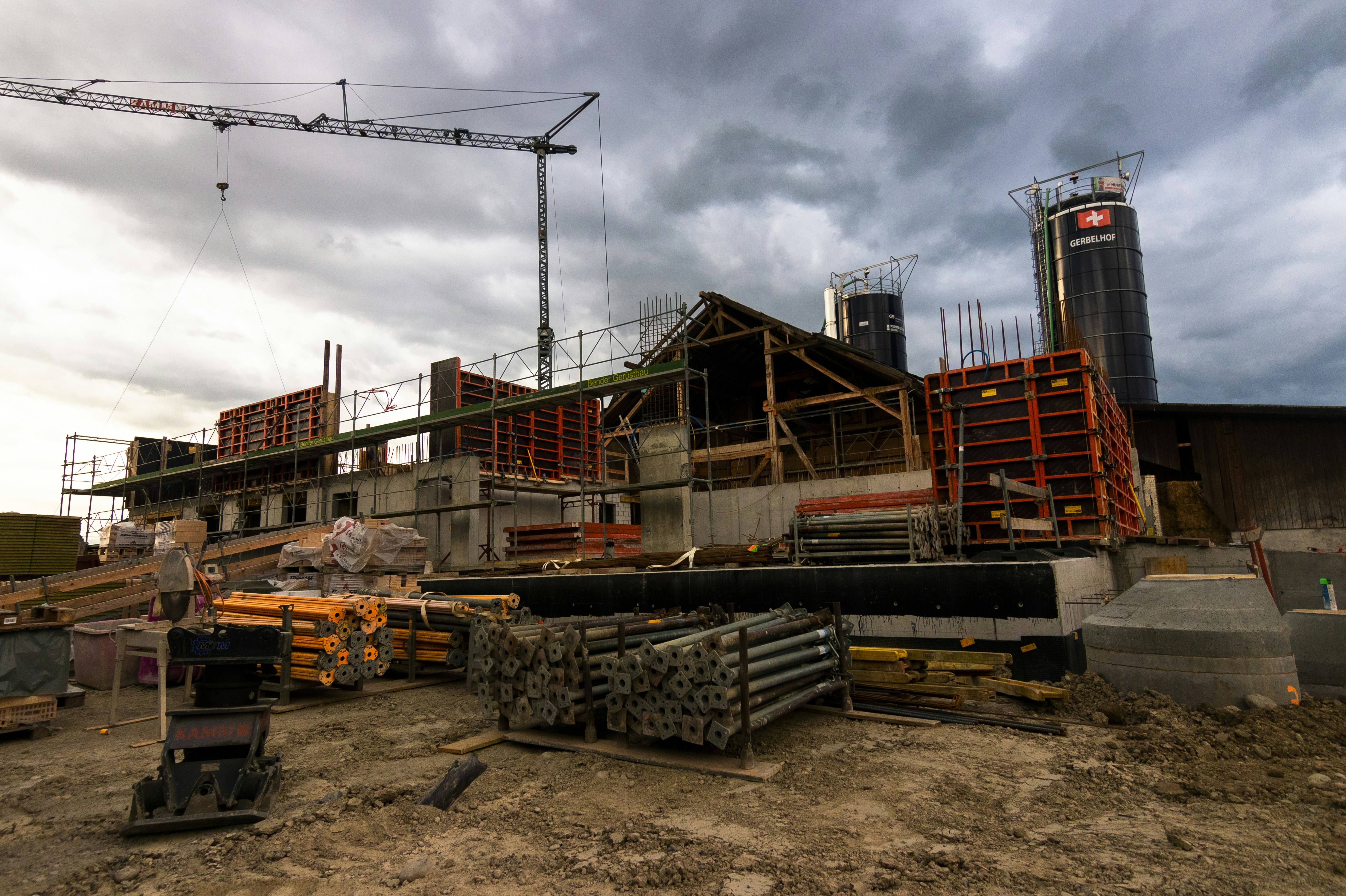Panoramic view of building construction. Various pieces of form work, heaps of struts, scaffolding and other equipment.