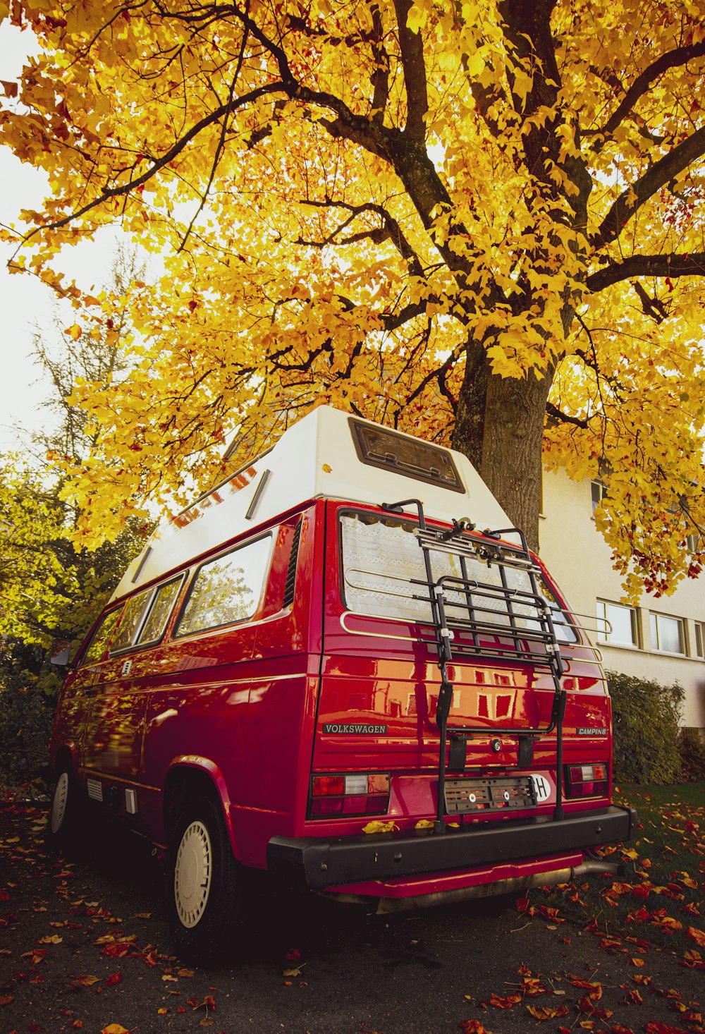 red van parked beside yellow leaf tree