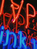 Transparent LED display glowing with vibrant colors in a bustling city storefront.