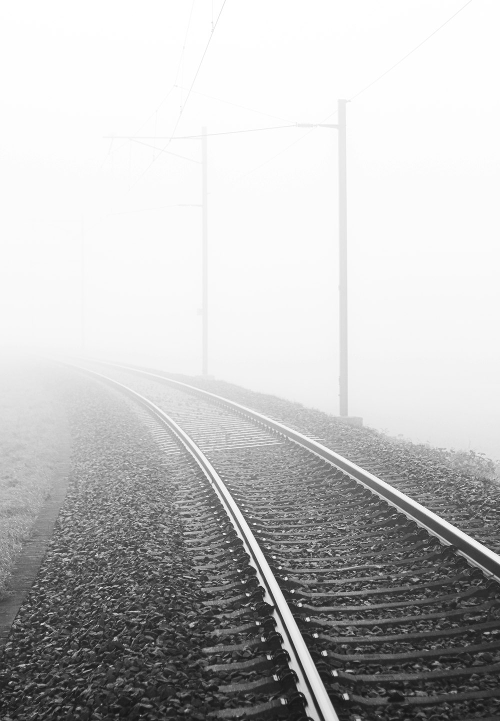 foto em tons de cinza do trilho do trem