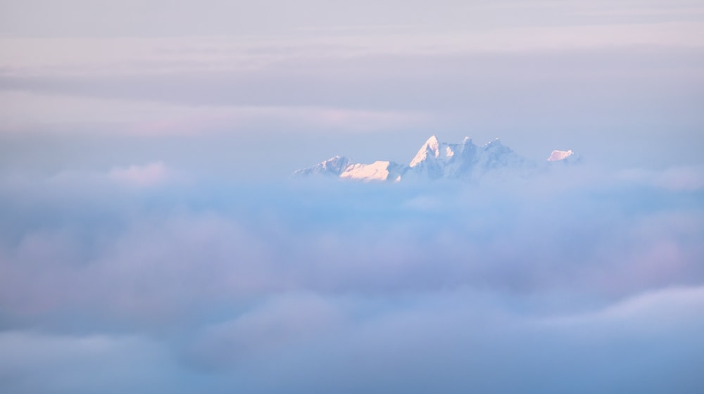 white clouds over snow covered mountains