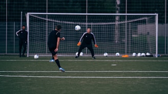 2 men playing soccer on green field during daytime