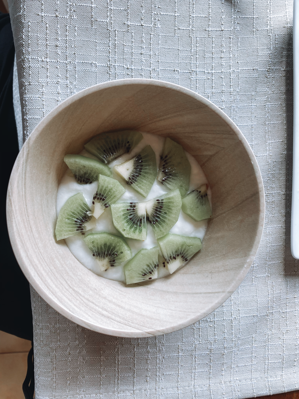sliced kiwi fruit in brown wooden bowl