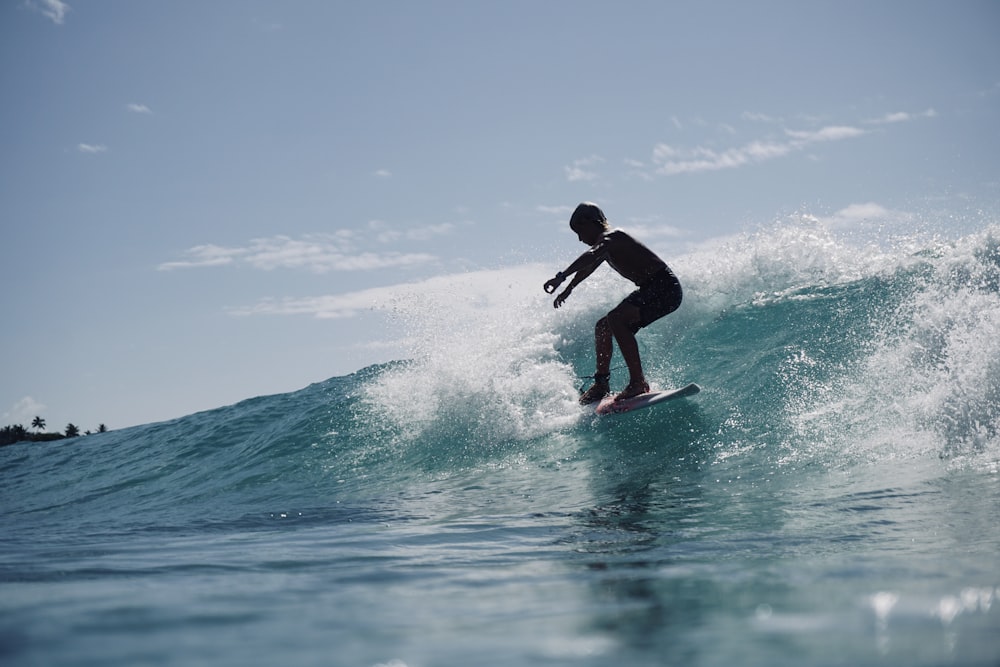 man in black wet suit surfing on sea waves during daytime