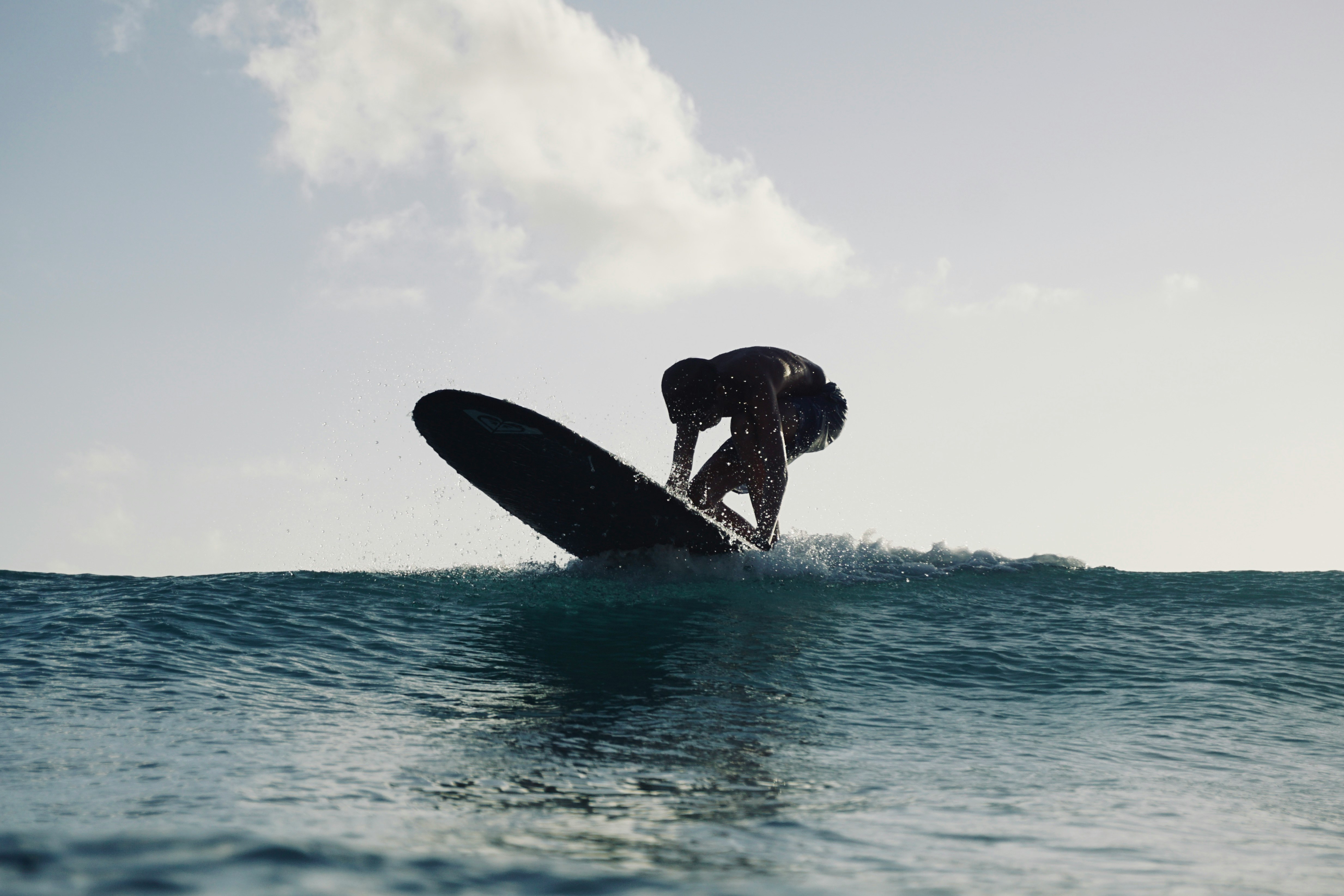 man surfing on sea during daytime