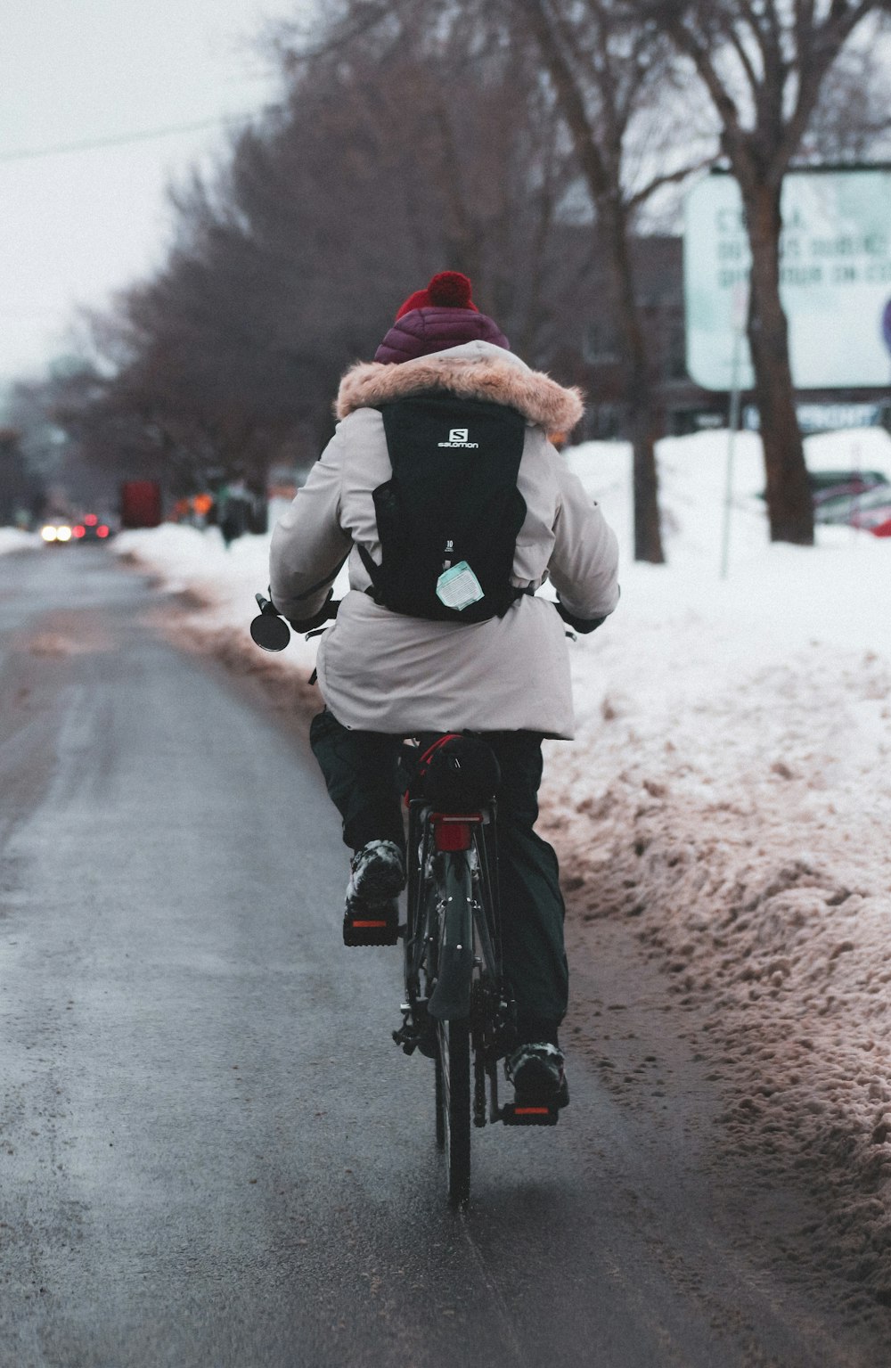 man in black jacket riding bicycle on road during daytime