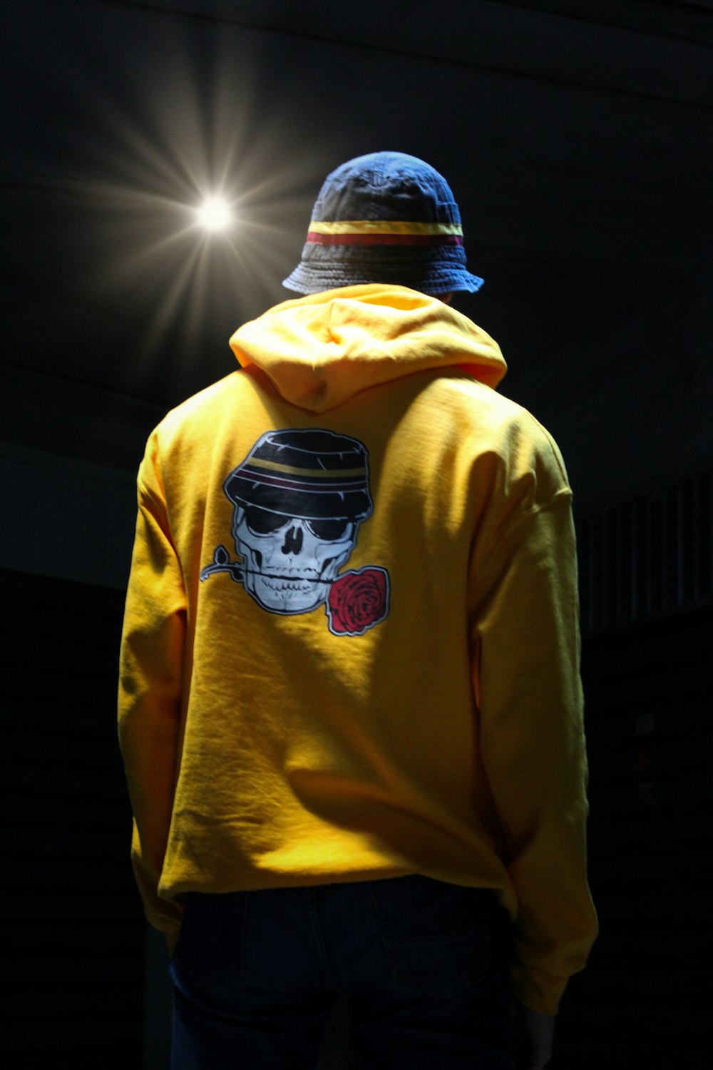 person in yellow hoodie wearing blue and white knit cap