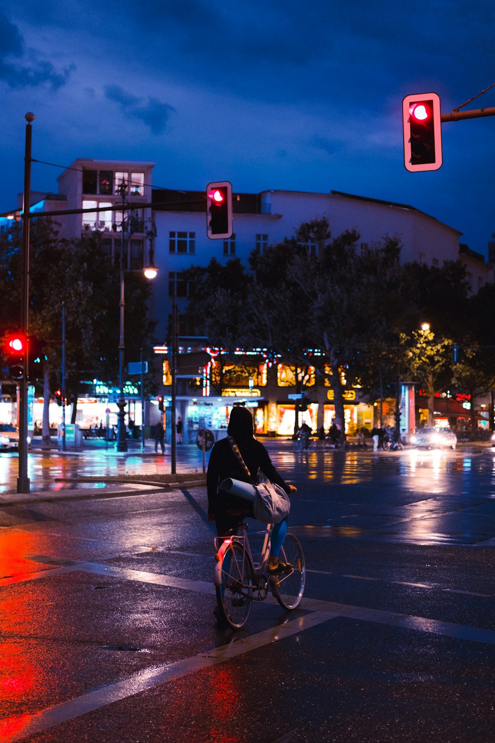 hombre en chaqueta negra montando en bicicleta en la carretera durante la noche