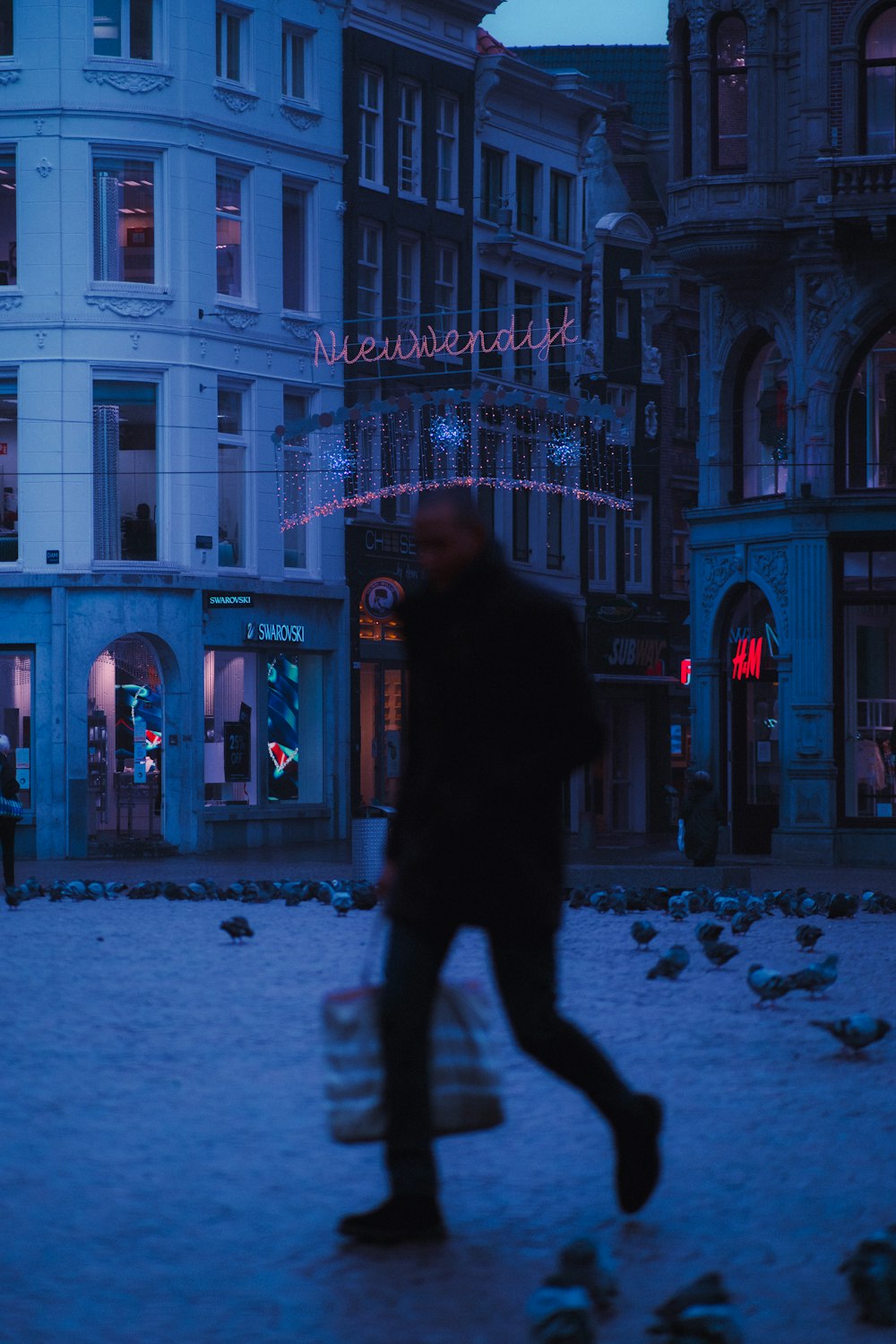 man in black jacket walking on snow covered ground