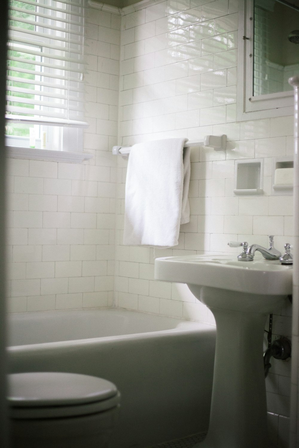 white towel on white ceramic bathtub